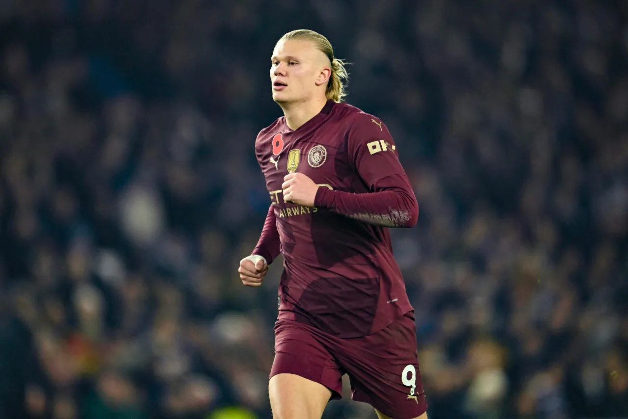 Erling Haaland w bordowym stroju Manchesteru City, gotowy do zdobywania bramek w Lidze Mistrzów. Jego pozycja sugeruje, że jest liderem klasyfikacji strzelców.