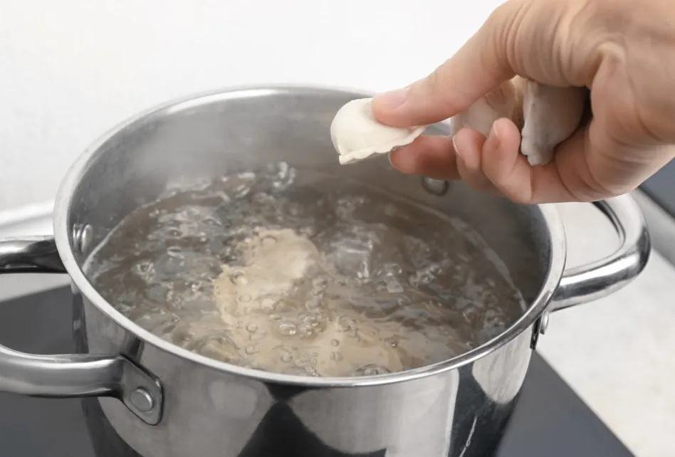 gotowanie pierogów w garnku, wrząca woda, pierogi w wodzie