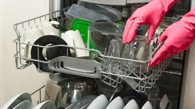 brudne naczynia w zmywarce przed myciem, np. patelnia i naczynie do zapiekania