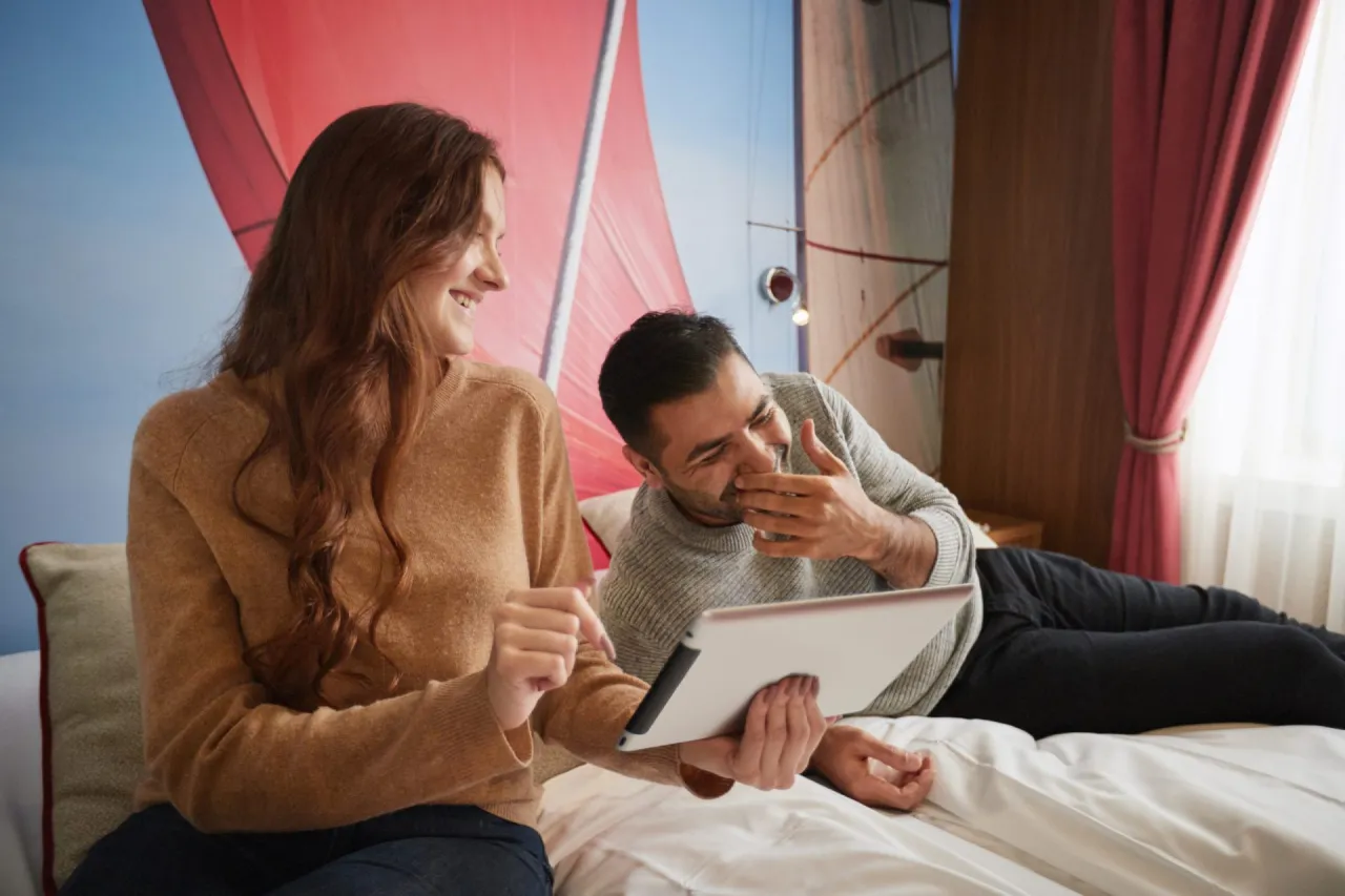 Osoba rezerwująca nocleg online z uśmiechem