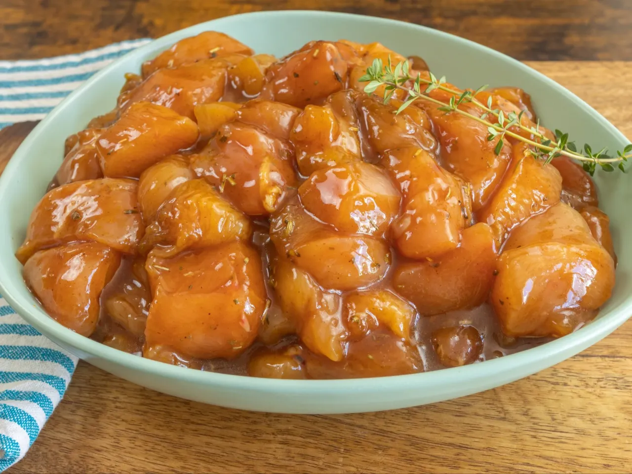 Kawałki piersi kurczaka w sosie, gotowe do smażenia. Dowiedz się, jak długo smażyć pierś z kurczaka, by była idealna.