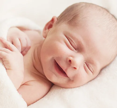 niemowlę uśmiecha się świadomie do rodzica