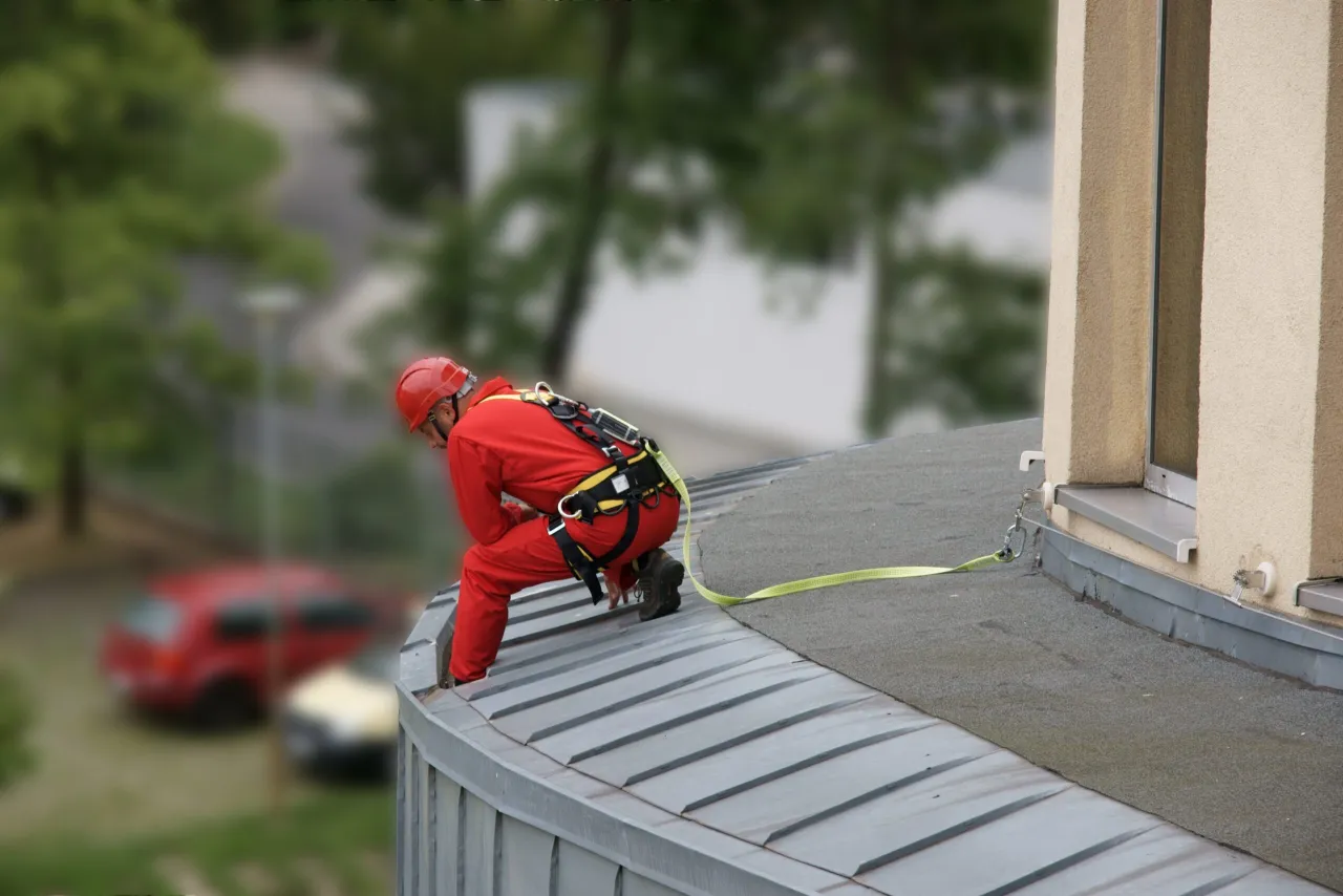 dekarz w uprzęży bezpieczeństwa