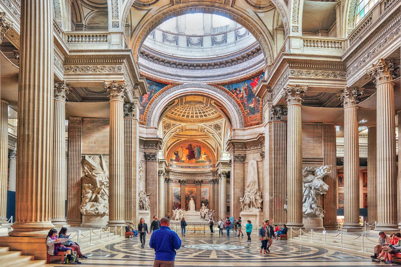 Wnętrze Panteonu w paryskiej dzielnicy łacińskiej. Monumentalne kolumny, kopuła i malowidła tworzą majestatyczną atmosferę.
