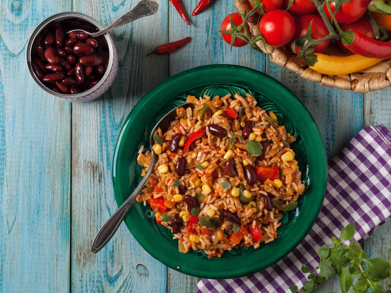 Kolorowy ryż z fasolą, kukurydzą i papryką na zielonym talerzu. Idealny pomysł, co zrobić na obiad z ryżem, gdy masz ochotę na coś sycącego.