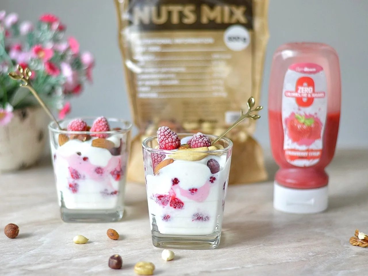 Idealne śniadanie przed treningiem rano: jogurt z malinami, orzechami i syropem.