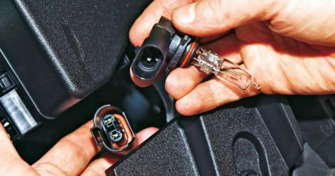 Dłonie trzymają nową żar&oacute;wkę i złącze, pokazując, jak wymienić żar&oacute;wkę w samochodzie.