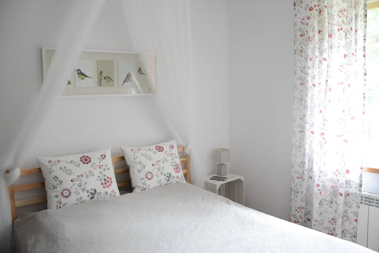 Jak zrobić stelaż do baldachimu? Białe zasłony i pościel w ptaszki tworzą przytulną sypialnię.