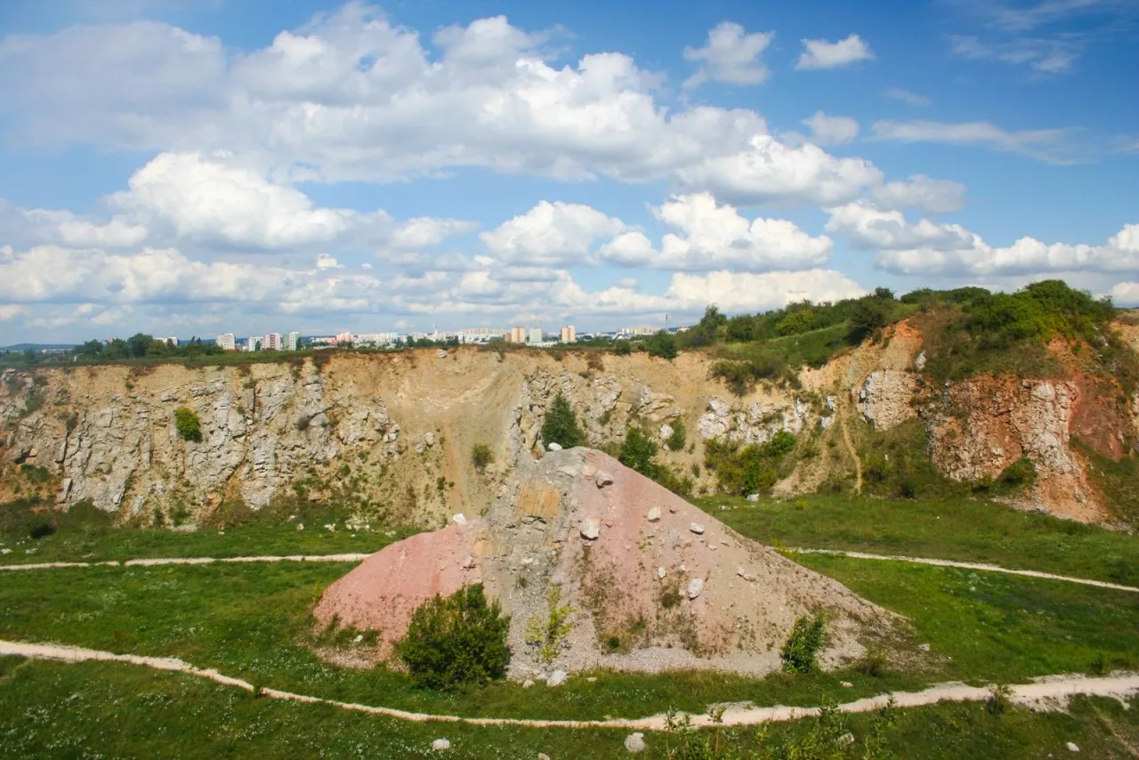Krajobraz kamieniołomu, kt&oacute;ry jest częścią rezerwatu przyrody Kielce. W oddali widać zabudowania miejskie.