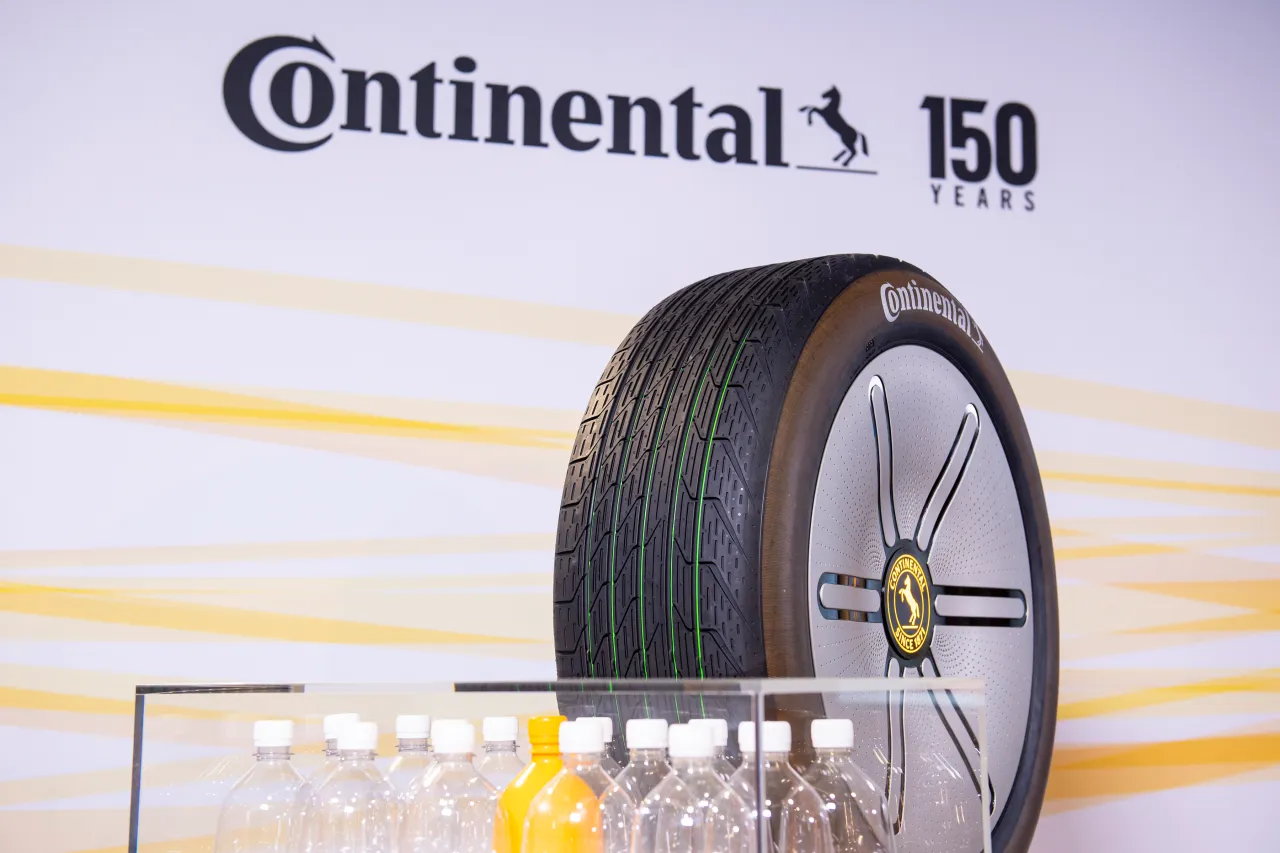 Opony Continental produkuje firma Continental AG. Na zdjęciu koło z logo firmy i butelki.