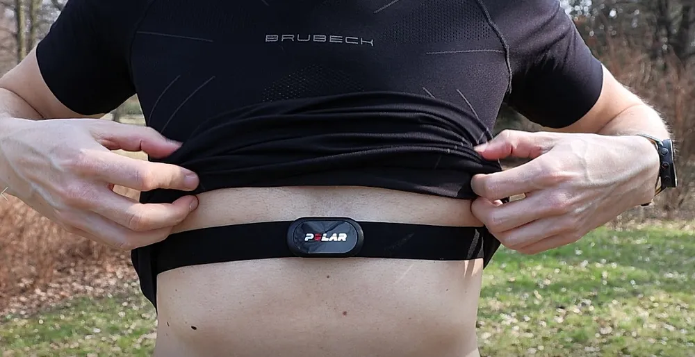 Biegacz z pulsometrem na nadgarstku i pasem na klatce piersiowej
