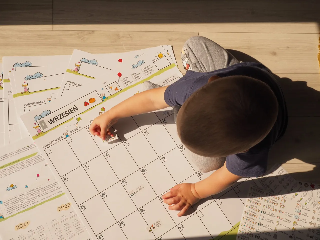 kalendarz z zaznaczonymi datami i śpiące dziecko