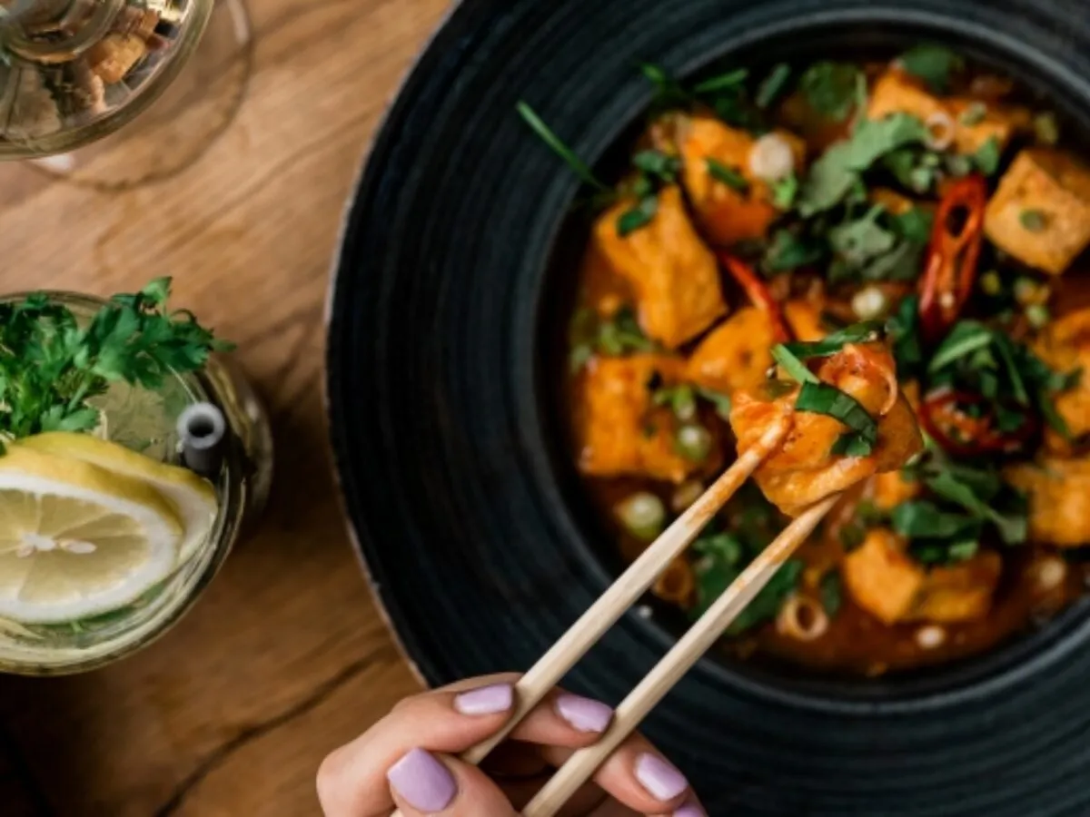 Pikantne tofu w sosie z chili i kolendrą &ndash; idealne, co podać opr&oacute;cz sushi. Obok drink z cytryną i miętą.