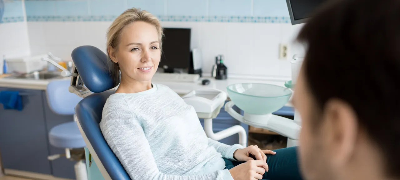 Rejestracja do dentysty, kobieta rozmawia przez telefon w recepcji gabinetu stomatologicznego