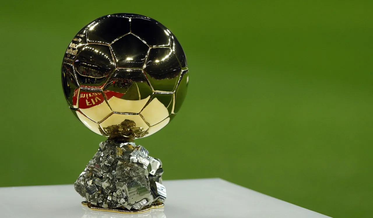 Złota Piłka, symbol piłkarskiej chwały, lśni na tle zieleni. Jej wartość to nie tylko kruszec, ale marzenia milion&oacute;w.