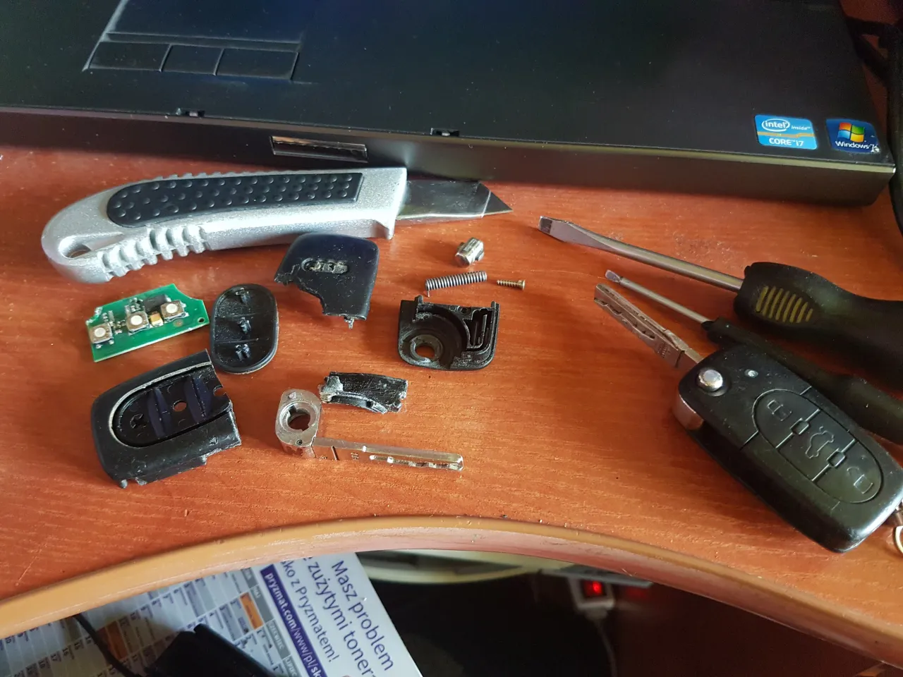 Rozłożony kluczyk samochodowy, płytka drukowana, śrubokręty i nożyk – narzędzia do samodzielnej próby, jak zresetować immobilizer.