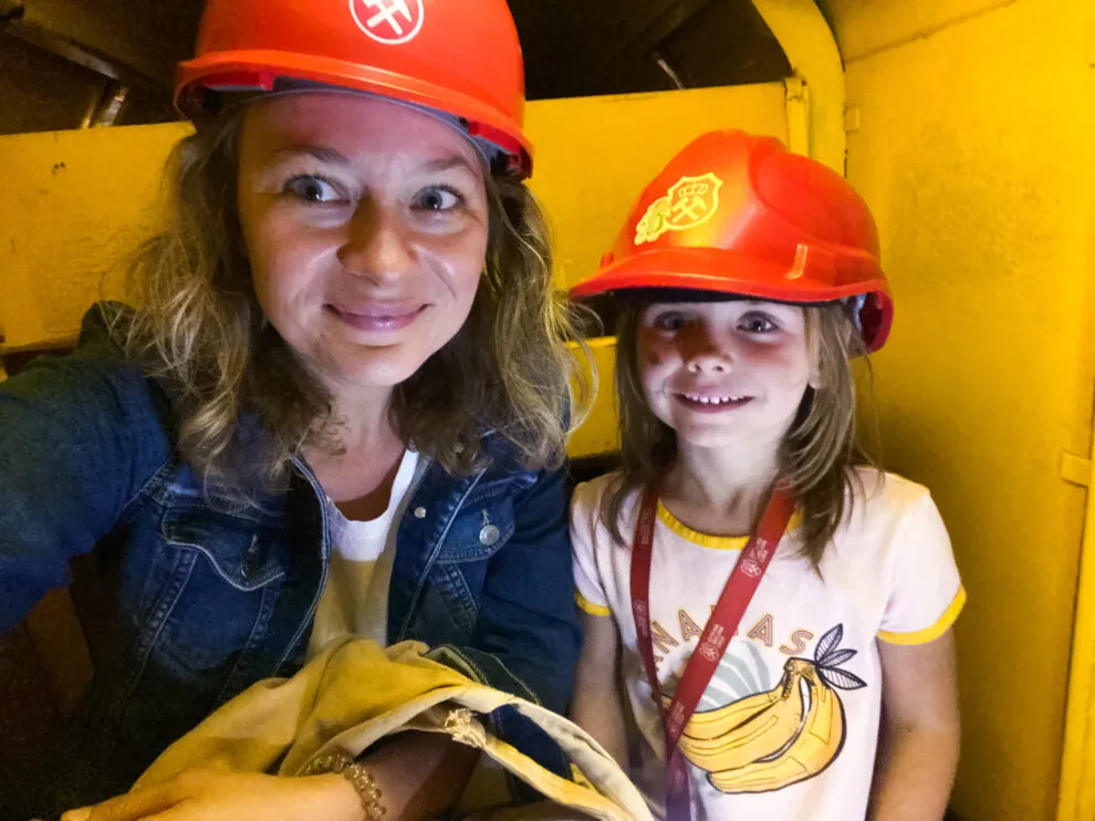 Dzieci w kaskach zwiedzające kopalnię Guido lub Sztolnię Kr&oacute;lowa Luiza