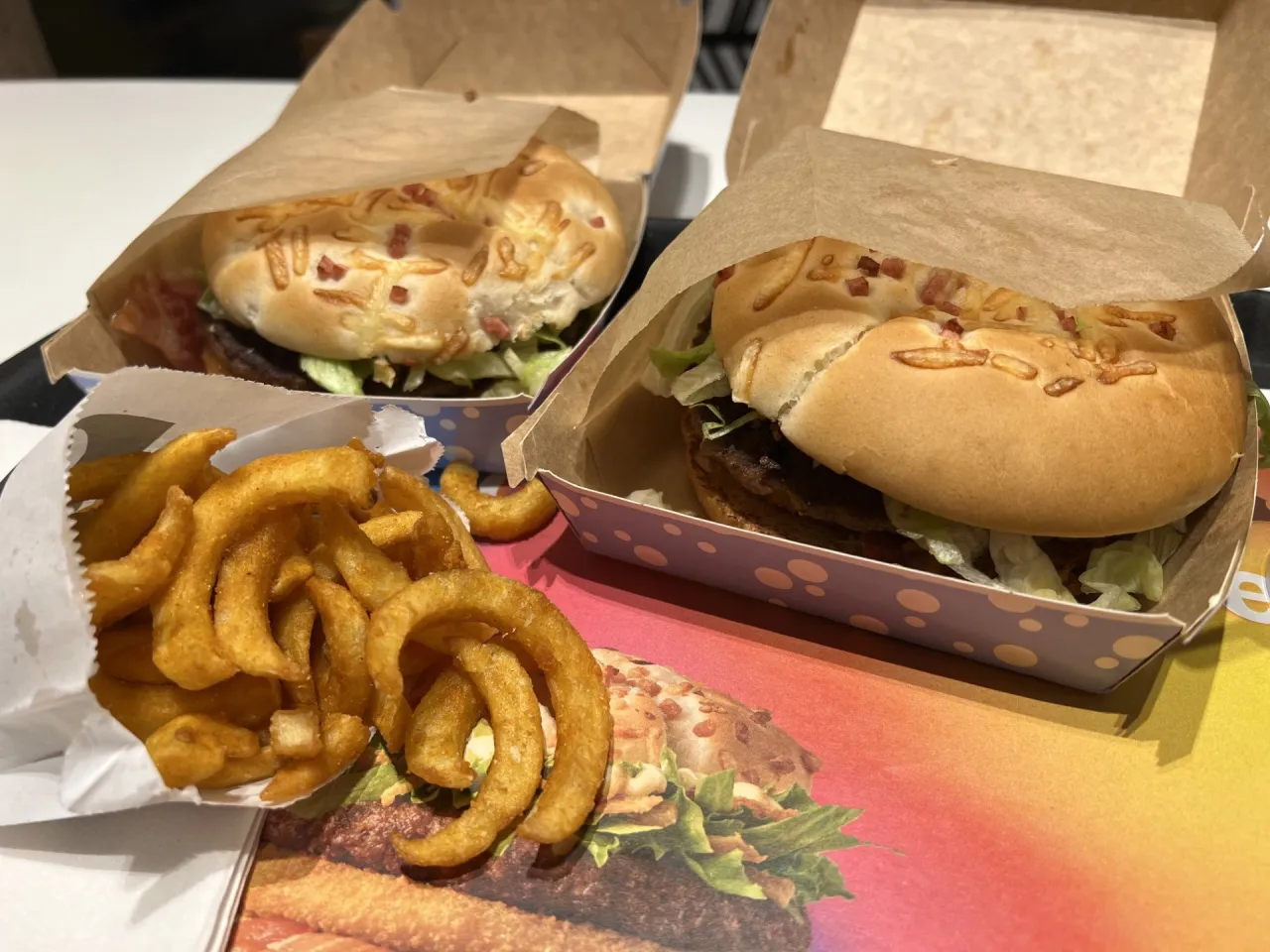 Dwa burgery drwala z chrupiącymi frytkami w papierowych opakowaniach. Czekam aż będzie burger drwala!