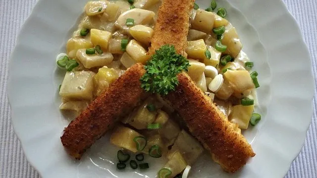 Frischer Kohlrabi und mehlig kochende Kartoffeln auf einem Holzbrett