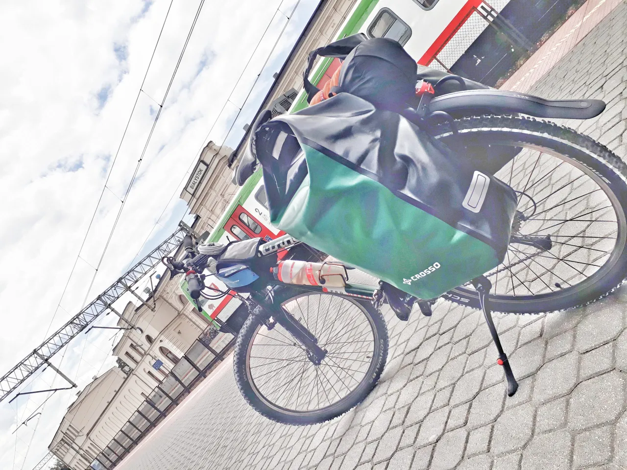 Rower z sakwami na dworcu w Białymstoku, gotowy do odkrywania tras rowerowych.