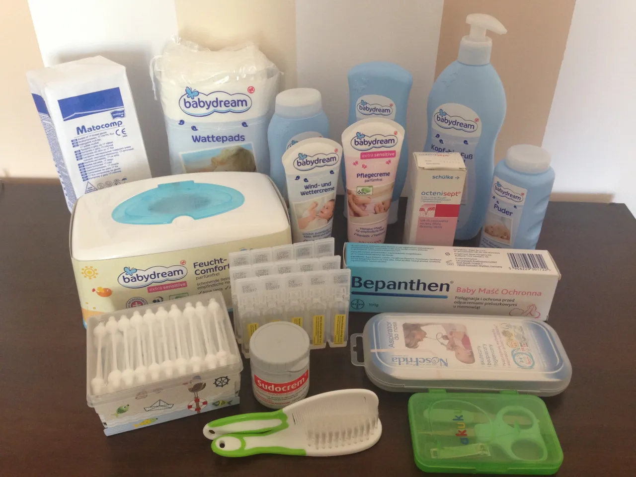 Zestaw kosmetyk&oacute;w dla noworodka: chusteczki, kremy, puder, płatki kosmetyczne, aspirator, grzebyk i nożyczki.