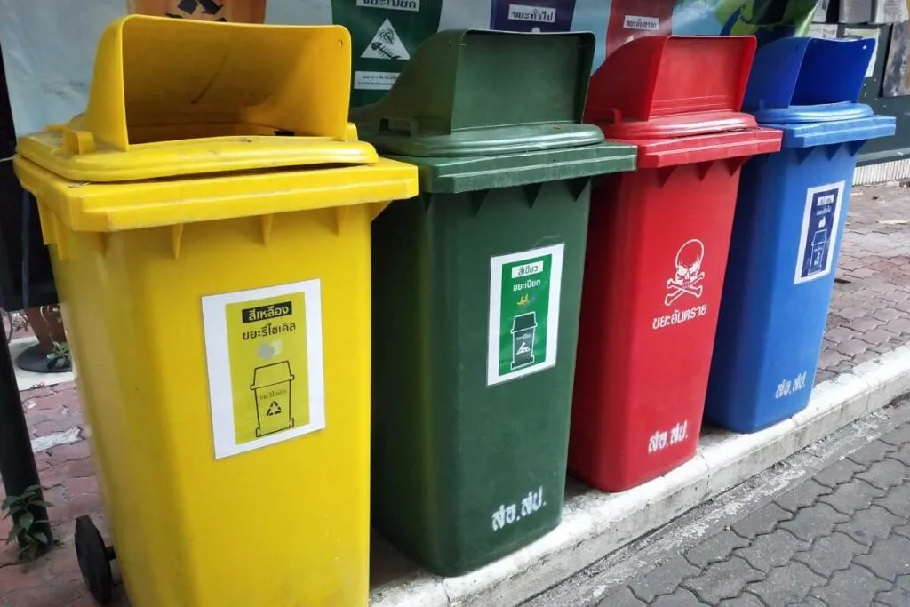 Kolorowe pojemniki do segregacji śmieci stojące obok siebie