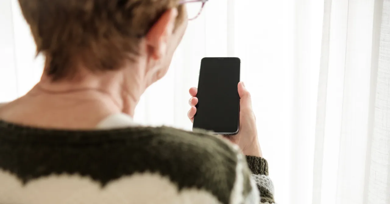 osoba trzymająca telefon szukająca zasięgu w domu