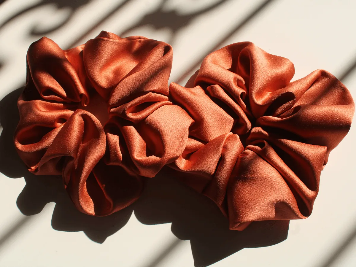 Dwie satynowe, pomarańczowe gumki do włos&oacute;w. Dowiedz się, jak uszyć gumkę do włos&oacute;w i stw&oacute;rz własne akcesoria.