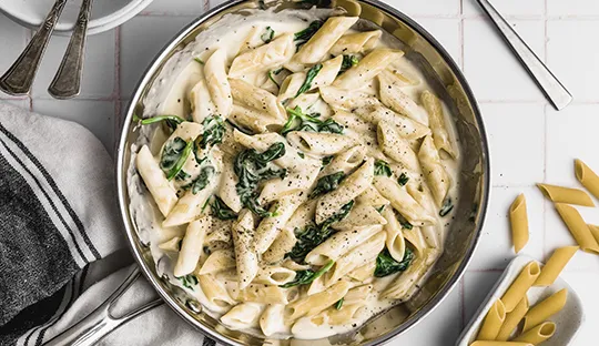 plato de pasta cremosa con espinacas y parmesano