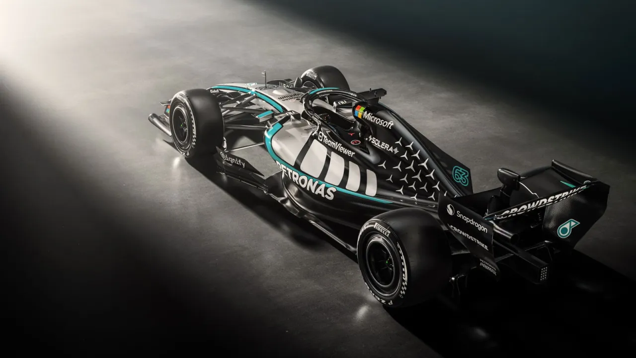 Nowoczesny bolid Mercedes-AMG Petronas F1 Team w czarno-srebrnej kolorystyce z turkusowymi akcentami, gotowy do wyścigu.