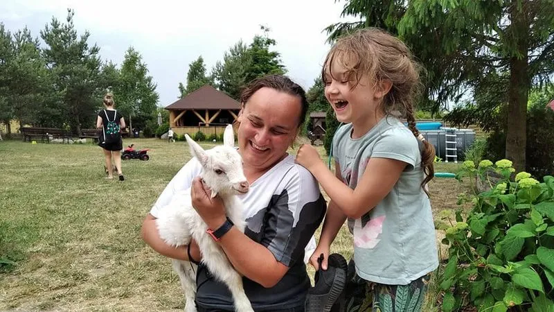 rodzina z małym dzieckiem w agroturystyce karmiąca zwierzęta
