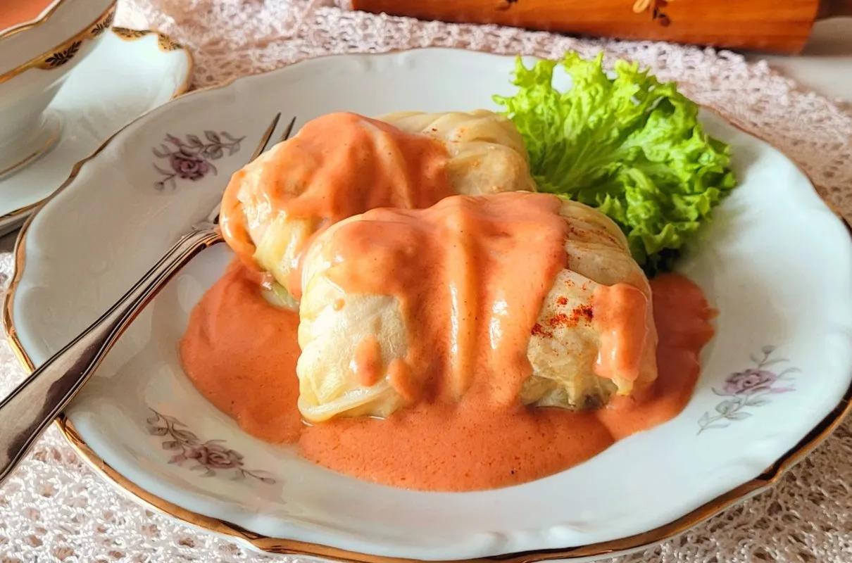 Dwa gołąbki w sosie pomidorowym na talerzu z sałatą. Czy z kapusty na gołąbki można zrobić surówkę? Tak, można!