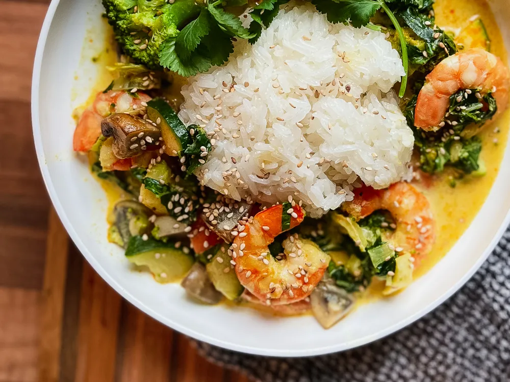 Asiatisches Garnelen-Curry mit Reis und frischem Koriander in einer Schale