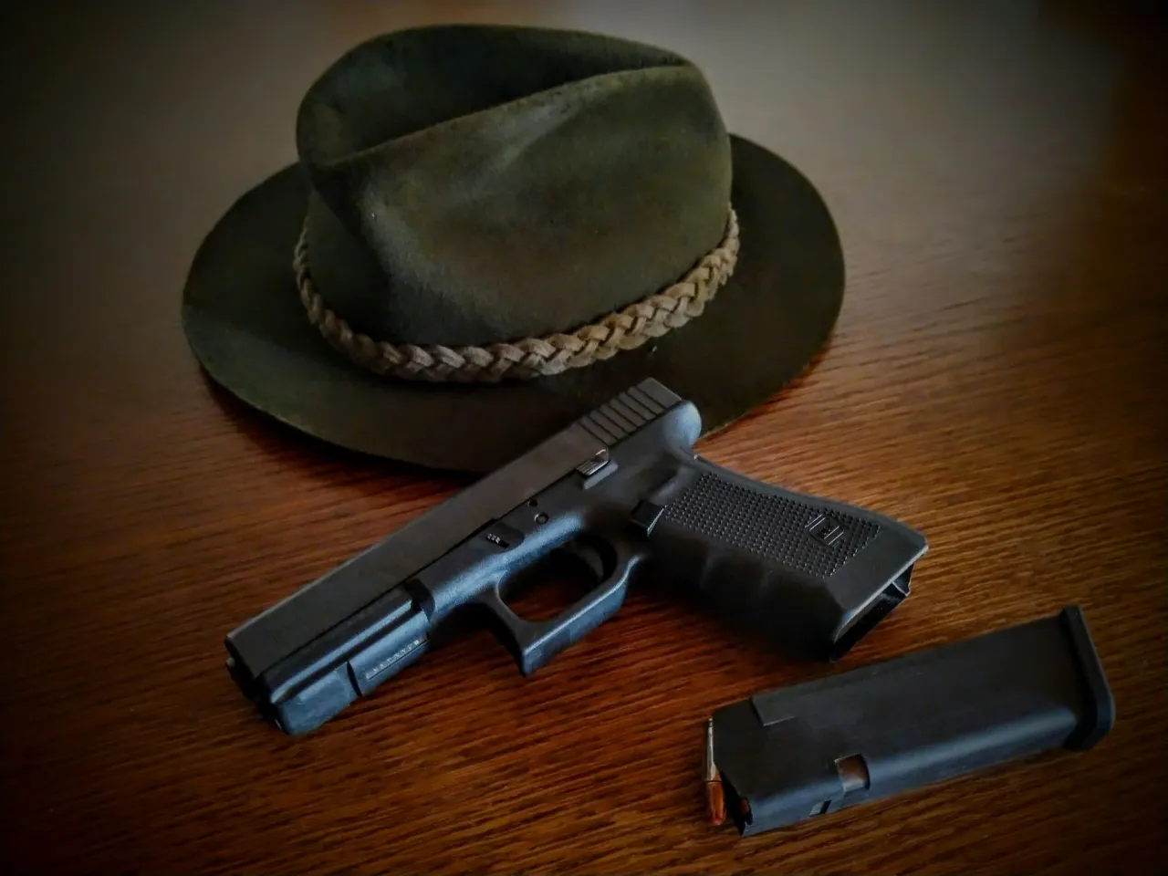 Zielony kapelusz myśliwski i pistolet z magazynkiem. Czy myśliwi mogą posiadać broń krótką? Tak, w określonych warunkach.