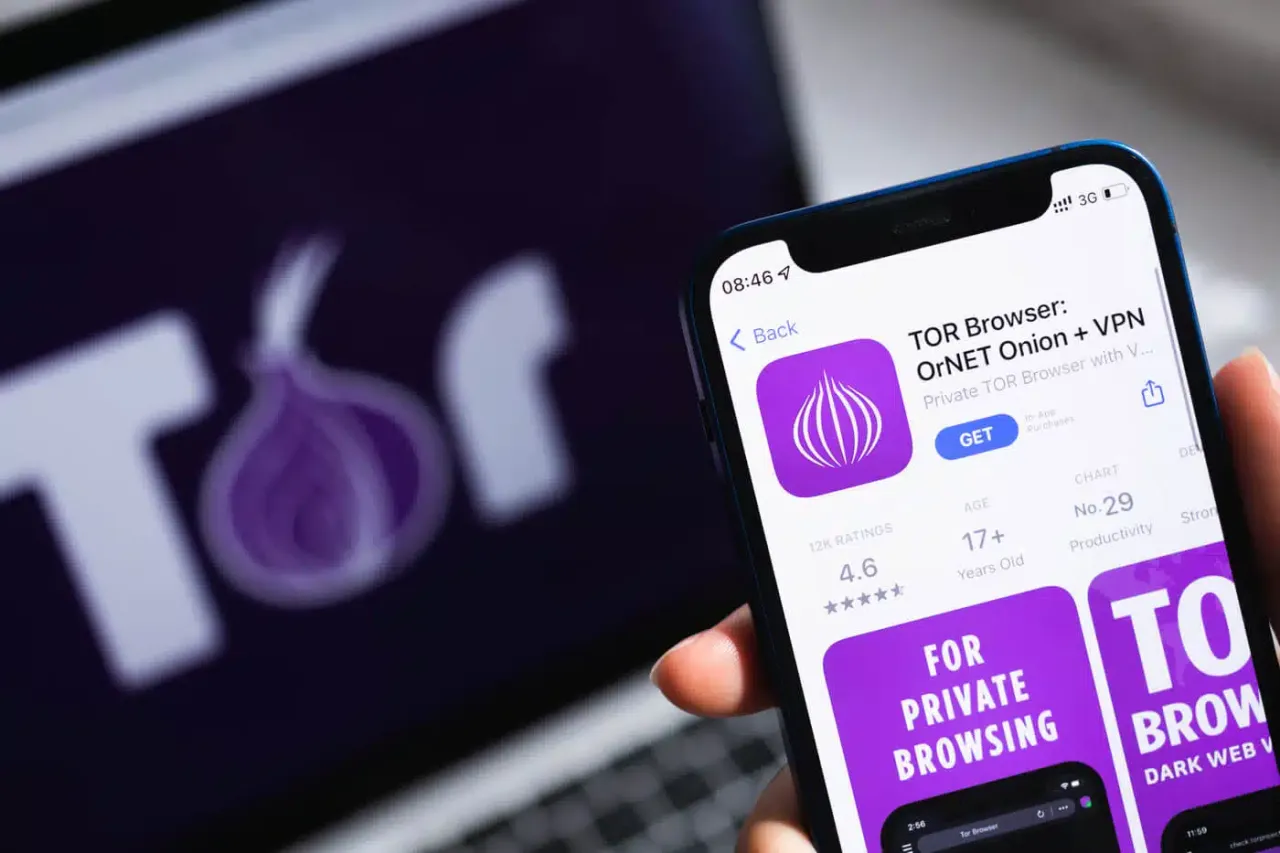 Telefon pokazuje aplikację TOR Browser, a w tle logo TOR. Prywatność w sieci jest ważna.