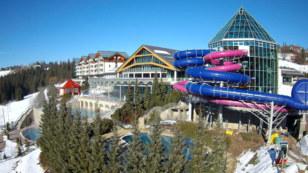 Atrakcje w Bukowinie Tatrzańskiej: baseny termalne i zjeżdżalnie wodne w otoczeniu górskiego krajobrazu.