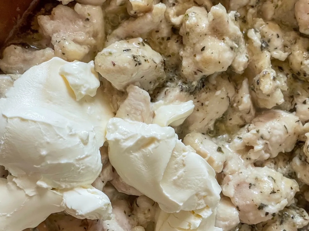 Kremowy sos do piersi z kurczaka, z kawałkami mięsa w sosie śmietanowym z ziołami.
