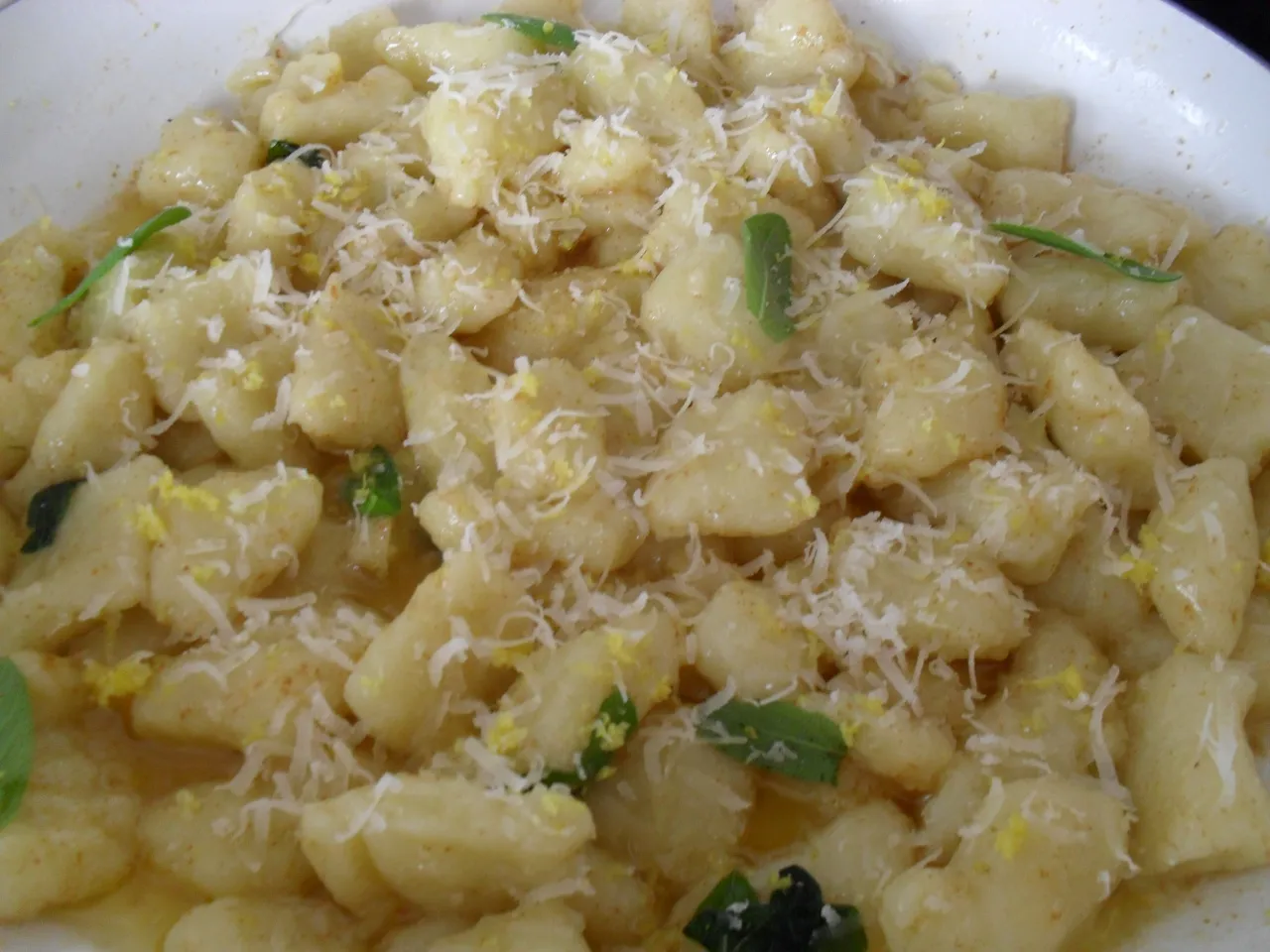 Pyszne gnocchi z masłem i szałwią, posypane parmezanem i skórką cytrynową. Idealne na szybki obiad.