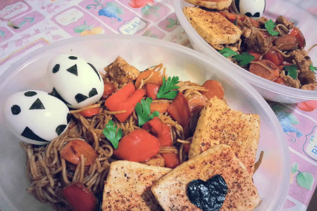 Japończycy jedzą na śniadanie makaron z warzywami, tofu i jajka ozdobione jak pandy.