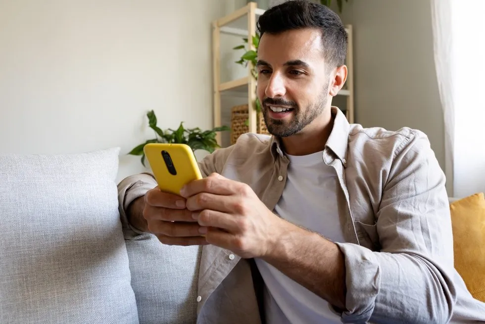 Osoba odbierająca telefon z uśmiechem