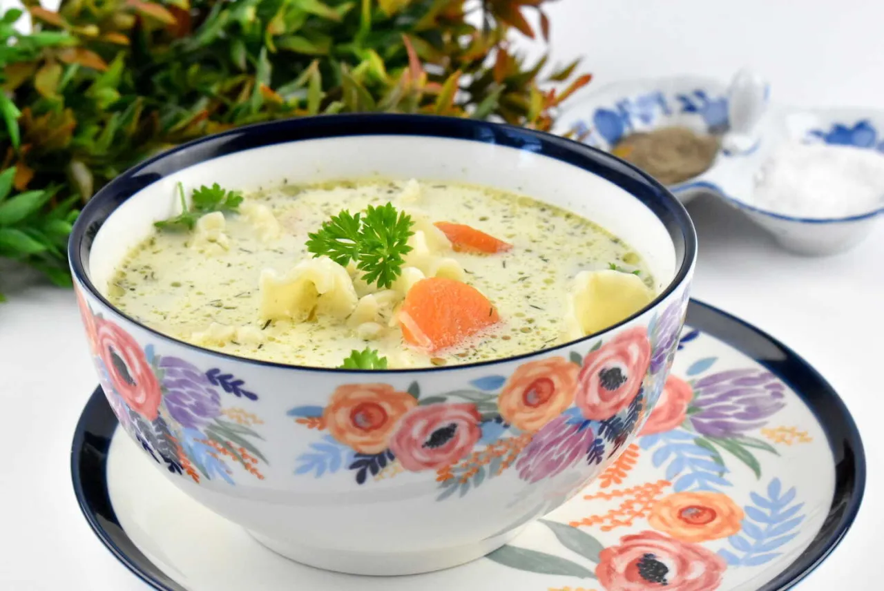 Kremowa zupa ogórkowa z marchewką i ziemniakami, ozdobiona natką. Czy roczne dziecko może jeść zupę ogórkową? Tak, jeśli jest łagodna.