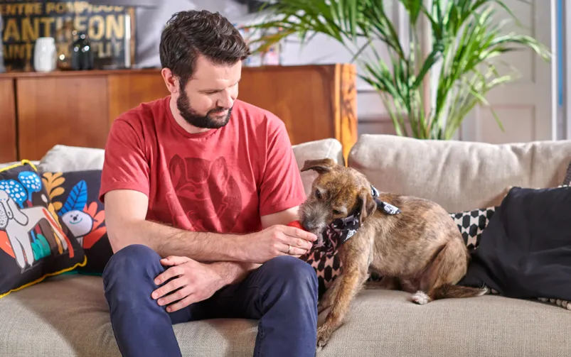 właściciel uspokaja szczeniaka