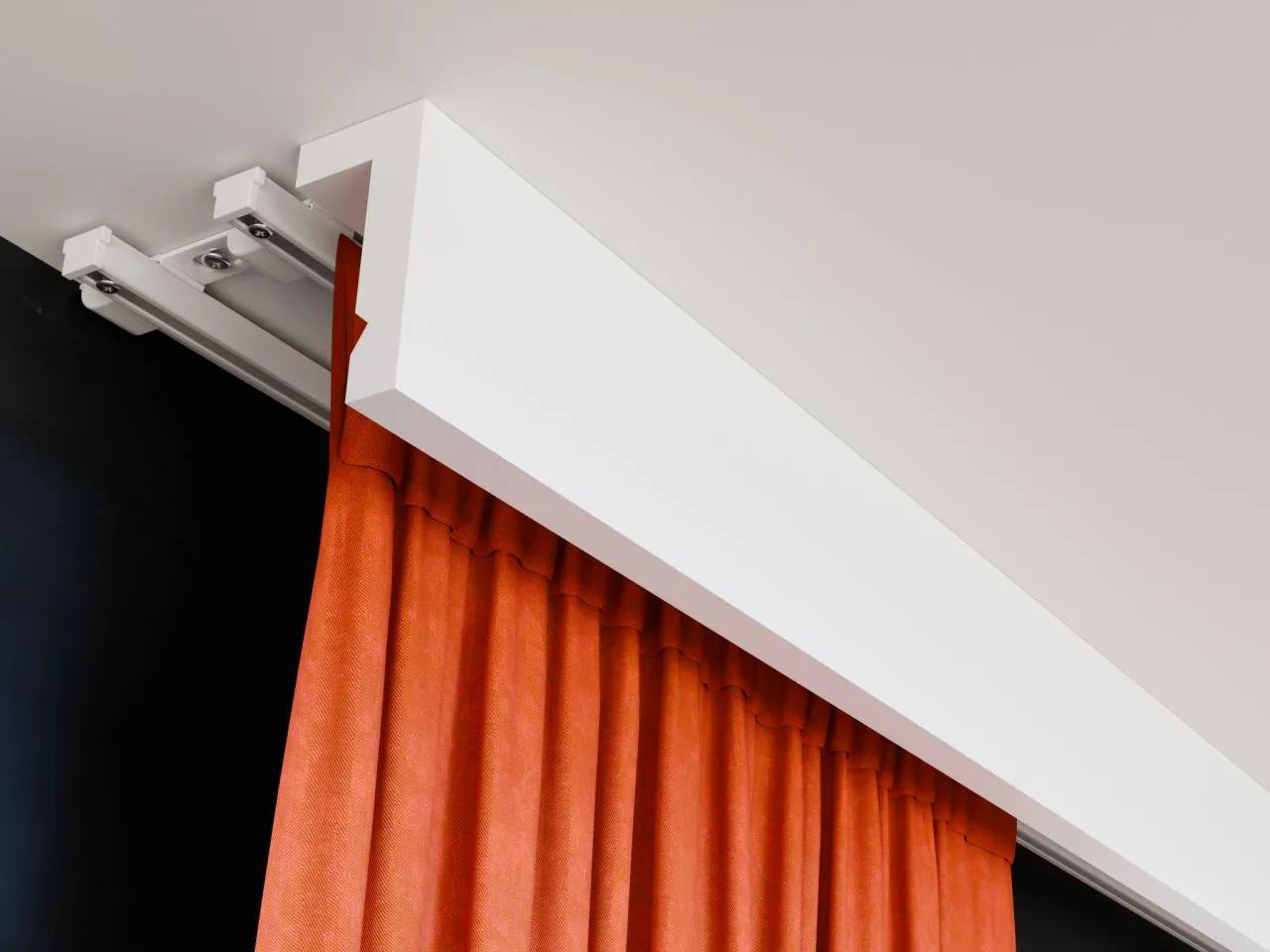 Nowoczesny karnisz sufitowy z białym wykończeniem, idealnie ukrywa szynę i wsp&oacute;łgra z pomarańczową zasłoną.