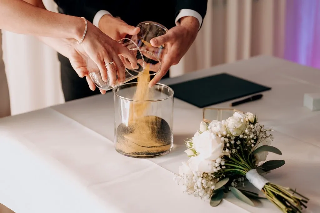 ceremonia piasku na ślubie dłonie pary młodej