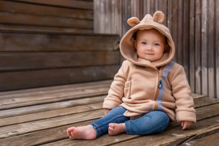 szczęśliwe niemowlę w kombinezonie wiosennym na spacerze w parku