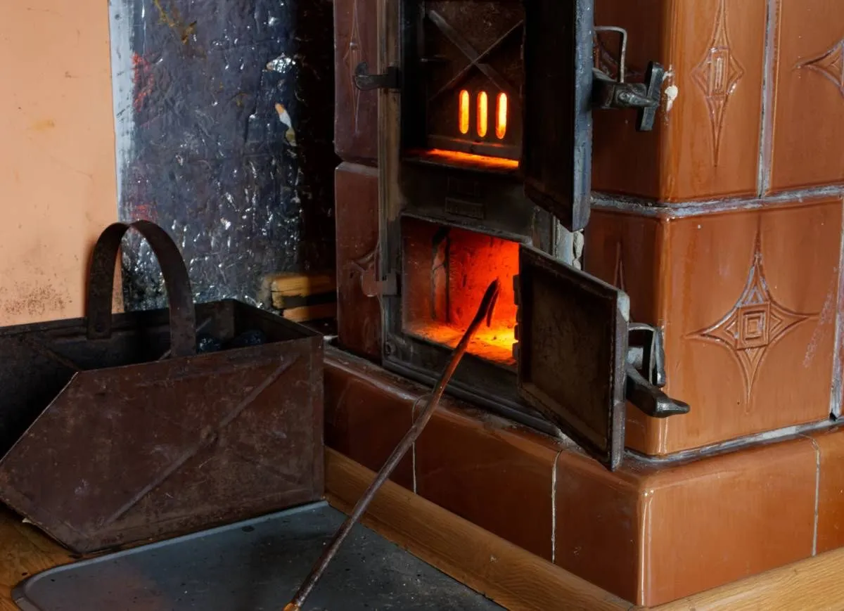 Piec kaflowy rozgrzany do czerwoności. Węgiel w zasobniku czeka na dorzucenie. Pytanie 