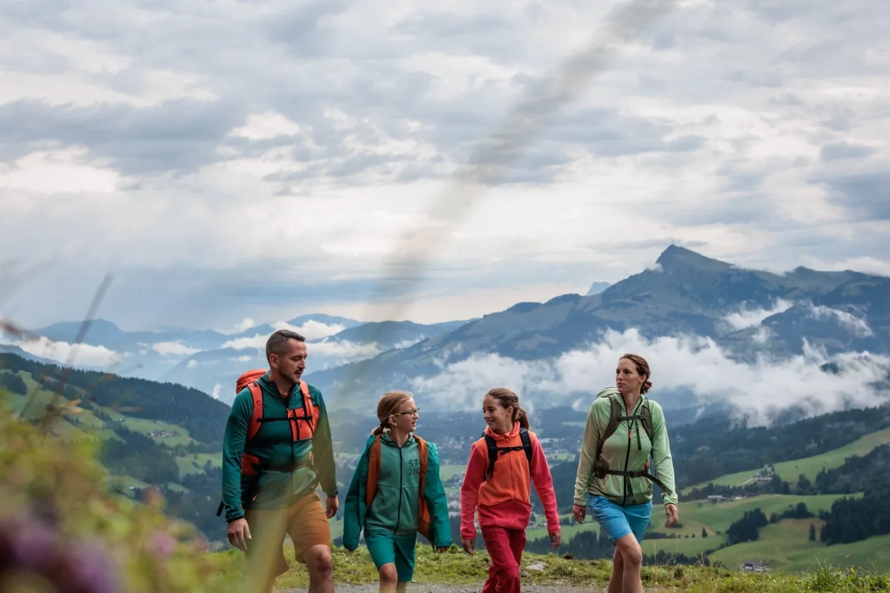 Rodzina wędruje po górach. Piękny krajobraz, chmury i zielone wzgórza. Idealne miejsce, gdzie w góry z dziećmi.