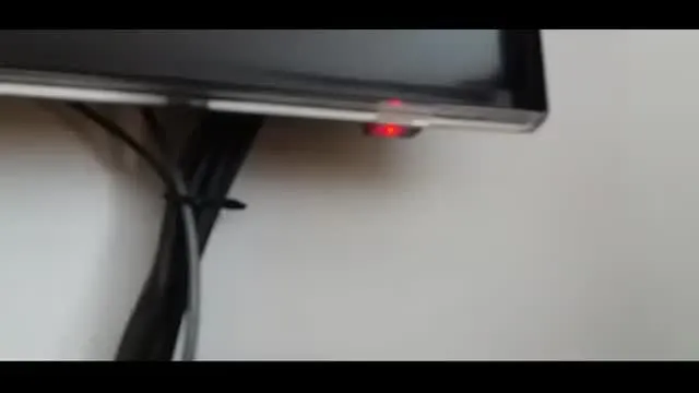 czerwona dioda standby na telewizorze w ciemnym pokoju