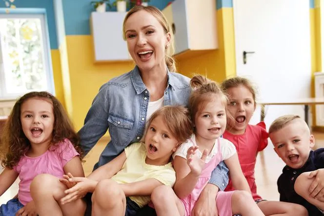 szczęśliwe dzieci w przedszkolu gotują razem z nauczycielem