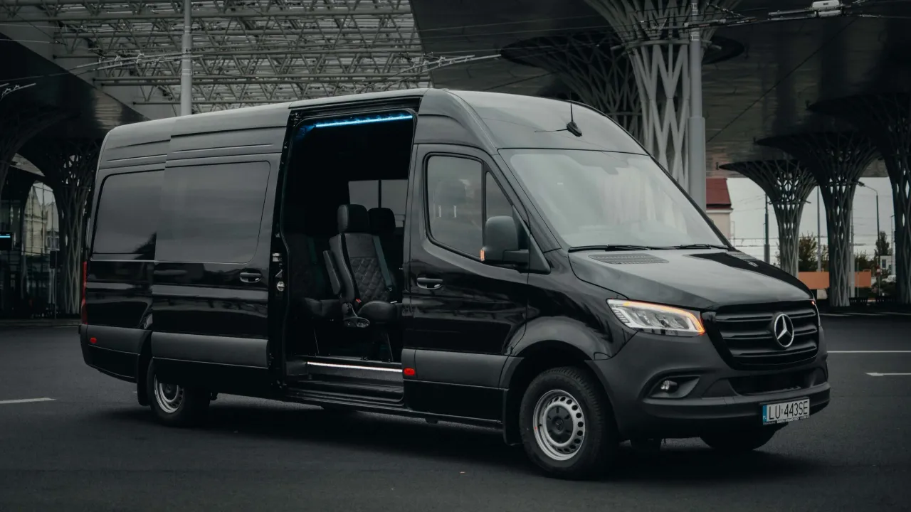 Czarny Mercedes Sprinter z otwartymi drzwiami, wygodne fotele w środku. Zastanawiasz się, ile kosztuje bus do Niemiec?